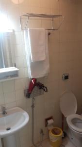 a bathroom with a sink and a toilet and towels at Balkony 407 - Três quartos Perto UNB in Brasilia