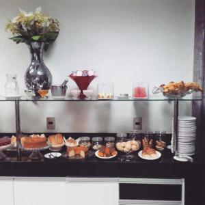 a kitchen with plates of food on a counter at Hotel Domus Itabira in Itabira