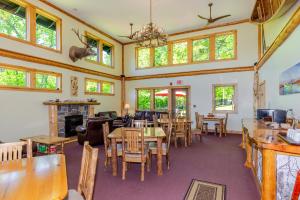 a dining room with tables and chairs and windows at Adirondack Spruce Lodge in Wilmington