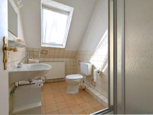 a bathroom with a sink and a toilet and a window at Wohnung Gesa in Alkersum in Alkersum