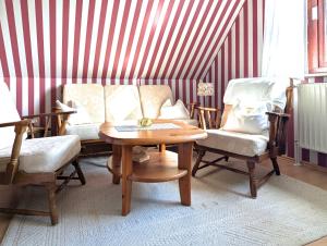 a room with a table and chairs and a striped wall at Wohnung Gesa in Alkersum in Alkersum