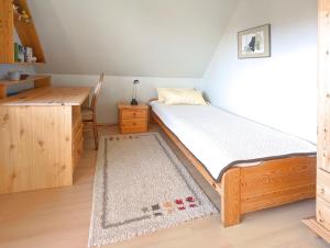 a small bedroom with a bed and a desk at Wohnung Gesa in Alkersum in Alkersum