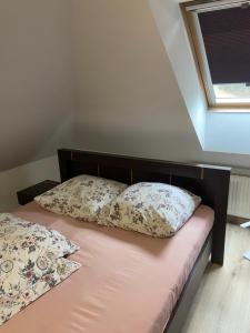 a bed with two pillows on it in a room at Willa Faustynka in Nałęczów