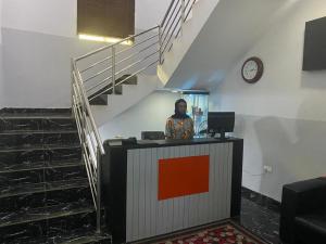 a woman standing at a desk in an office with a staircase at Hotel 101 & Apartments in Karsana
