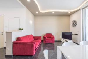 a living room with two red chairs and a tv at Crescent Luxury Retreat - Seafront Apartment Scala E in Salerno