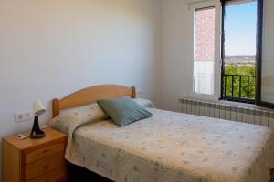 a small bedroom with a bed and a window at El Carmen in Toro