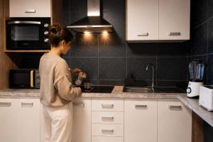 a woman standing in a kitchen preparing food at Private Terrace, Residential Area, Beach & Surf, El Médano in El Médano