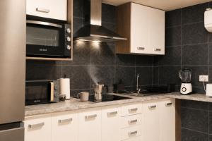 a kitchen with white cabinets and a microwave at Private Terrace, Residential Area, Beach & Surf, El Médano in El Médano +22 photos