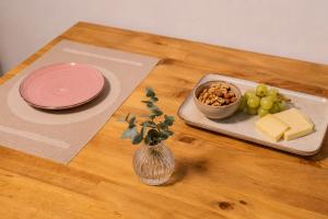 a wooden table with a plate of cheese and grapes at Private Terrace, Residential Area, Beach & Surf, El Médano in El Médano