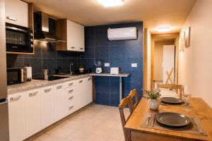 a kitchen with white cabinets and a wooden table at Private Terrace, Residential Area, Beach & Surf, El Médano in El Médano