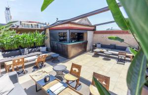 an outdoor patio with tables and chairs and a bar at Hotel Granados 83, a member of Preferred Hotels & Resorts in Barcelona