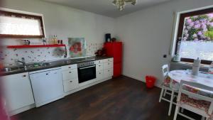 a kitchen with white cabinets and a red refrigerator at Ferienwohnung Aida in Baiersbronn +22 photos