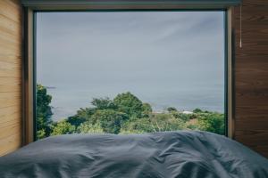 a large window with a view of the ocean at 森の宿 l ACAO FOREST 01 in Atami