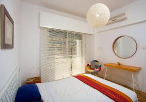 a bedroom with a bed and a desk and a window at SeaBreeze City Center Flat by TrulyCyprus in Limassol