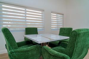 a conference room with green chairs and a white table at Royale Jazz Hotel in Kingston