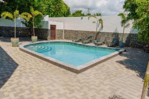 a swimming pool in a patio with chairs and a building at Royale Jazz Hotel in Kingston