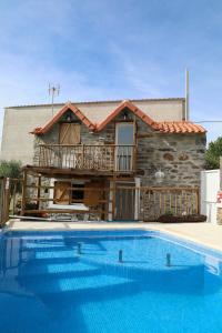 a house with a swimming pool in front of a house at Casa da Moleira in Chaveirinha
