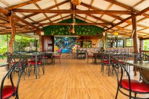 a dining room with tables and chairs and a game room at Cabañas Bella Vista in Hojancha