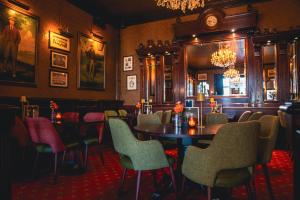 a restaurant with a table and chairs and a clock at Boutique Hotel De Doelen in Groningen