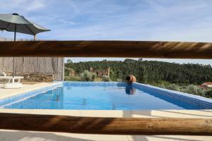 a swimming pool seen through a wooden fence at Casa da Moleira in Chaveirinha +11 photos