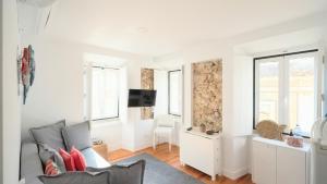 a living room with a couch and a tv at Apartamentos Aurea - Sesimbra in Sesimbra +57 photos
