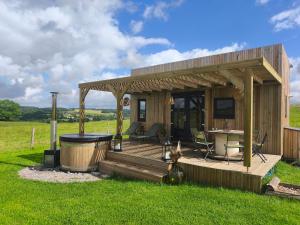 a small cabin with a deck with a television at L'instant bucolique in Origny-en-Thiérache