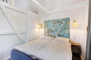 a bedroom with a bed with a painting on the wall at Gästehaus Altes Forstamt Sinntal in Sinntal