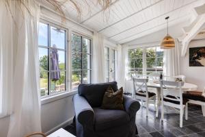 a living room with a chair and a table and windows at Gästehaus Altes Forstamt Sinntal in Sinntal