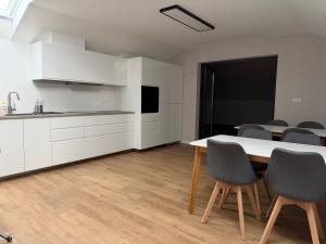 a kitchen and dining room with a table and chairs at Baltic Waves Ex LAZUR in Gąski