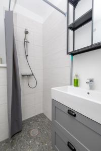a bathroom with a white sink and a shower at Obinitsa Apartment in Obinitsa +30 photos