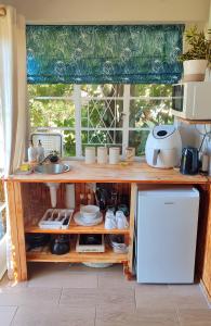 a kitchen with a counter with a sink and a refrigerator at Willowlea Cottage in Underberg