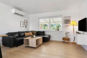 a living room with a black couch and a table at SB134-Sydals-Osterbyvej-54-B in Østerby