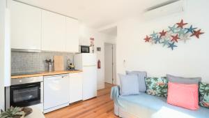 a living room with a couch and a kitchen at Apartamentos Aurea - Sesimbra in Sesimbra
