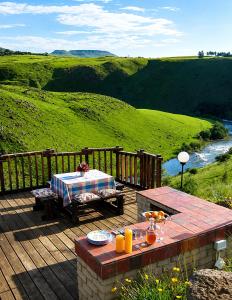 a wooden deck with a table and a picnic table at Great Dane at Brittlewood in Underberg
