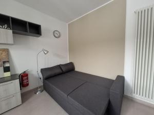 a living room with a couch and a clock on the wall at Eira Apartment Potenza in Potenza