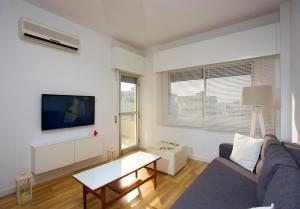 a living room with a couch and a tv at SeaBreeze City Center Flat by TrulyCyprus in Limassol
