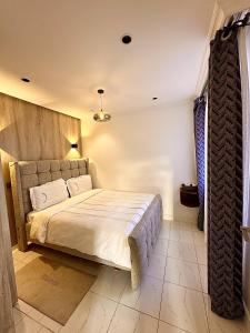 ein Schlafzimmer mit einem großen Bett in einem Zimmer in der Unterkunft Residence Next Door Green Zone in Kiambu + 6 Fotos