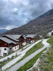 a dirt road in a village with a mountain at Appartement Orelle spa et piscine in Orelle