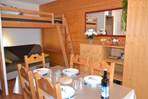 a dining table and chairs in a room with bunk beds at Appartement Orelle spa et piscine in Orelle