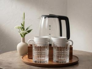 a tray with two glasses of water and a kettle at Zemlinsky Hof in Payerbach