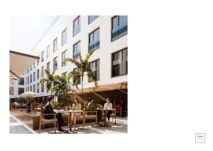 people sitting at tables outside of a building at Aduana Suites in Salou