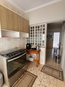 a kitchen with a stove and a wooden table at Confortável e bem localizada, com 2 quartos e garagem in São João da Boa Vista
