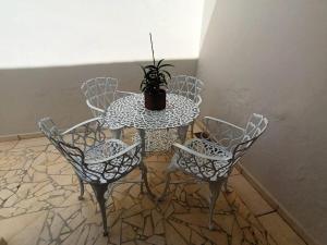 a table and chairs with a potted plant on it at Confortável e bem localizada, com 2 quartos e garagem in São João da Boa Vista +5 photos
