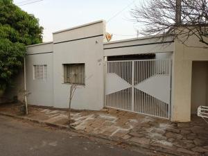 a white garage door with a gate on a house at Confortável e bem localizada, com 2 quartos e garagem in São João da Boa Vista