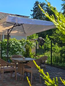 a table and chairs under a white umbrella at Dava&Davi in Ureki