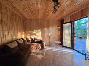 a living room with a couch in a wooden wall at Dava&Davi in Ureki