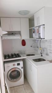 a white kitchen with a washing machine and a sink at Balkony 407 - Três quartos Perto UNB in Brasilia