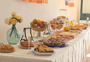 a table filled with different types of bread and pastries at Al Palmento Country Hotel in Syracuse