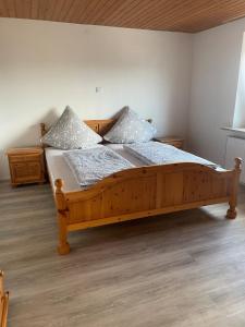 a wooden bed with two pillows on it in a room at Apartment Kuhl in Selb