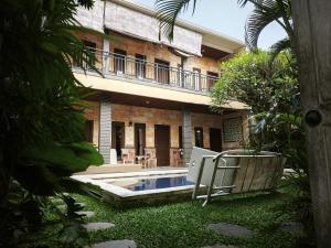 an external view of a house with a swimming pool at Sun Homestay Canggu in Canggu